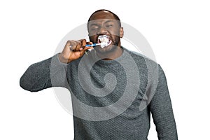 Black man enthusiastically brushing teeth.