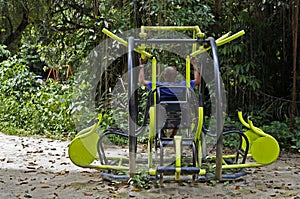 Black man exercising on public gym equipment at `Bosque da Freguesia`, Freguesia Forest Public Park