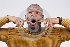 Black man, funny face or portrait in studio for comic, comedy and silly expression by white background. Male person