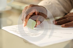 Black man hands erasing drawing with rubber on a desk