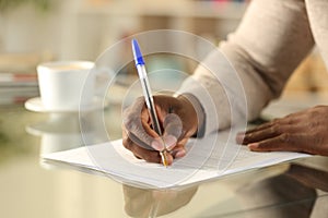 Black man hands filling out form on a desk photo