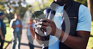 Black man, hands and volunteer with phone for communication, social media or chatting in nature. Closeup of African or