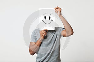 Black man holding paper with smiley face