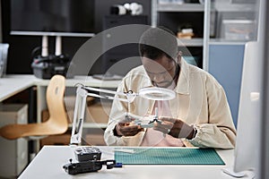 Black Man Inspecting Drone in Repair Shop