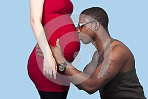 Black man kissing his white pregnant