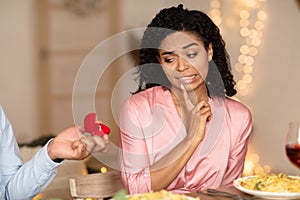 Black man making proposal with ring, woman rejecting