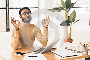 Black man meditating in office coping with stress