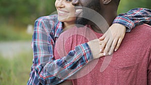 Black man and mixed race woman tenderly hugging, happy people smiling together