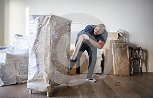 Black man moving furniture to new house