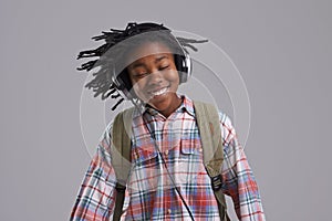 Black man, music and smile of a teenager with hip hop and rap audio in a studio. Relax, backpack and student with