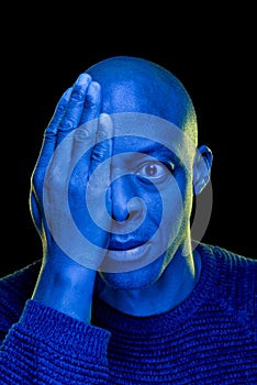 Black man with one eye covered with the hand and amazement expression. Blue light