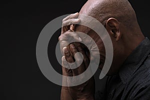 black man praying to god Caribbean man praying with black background stock photo