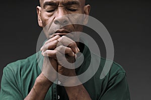 black man praying to god Caribbean man praying with black background stock photo