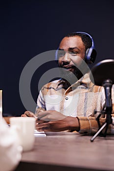Black man recording a podcast at home