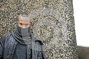 Black man with scarf covering face outdoors