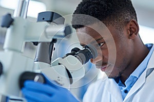 Black man, scientist and microscope for research, testing and study vaccine results or solution. Lens, doctor and male