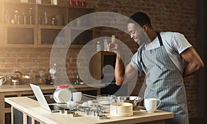 African-american man baking cookies at home kitchen