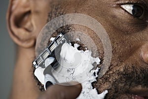Black man shaving his beard