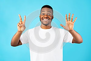 Black Man Showing Number Seven Smiling To Camera, Blue Background