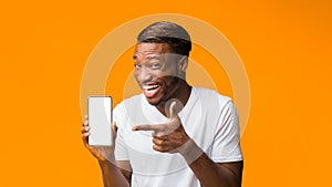 Black Man Showing Phone Blank Screen Standing, Orange Background, Mockup photo