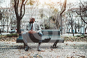 Black man sitting on a wooden bench