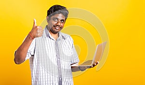 Black man smiling standing wear shirt using laptop computer and showing thumb up