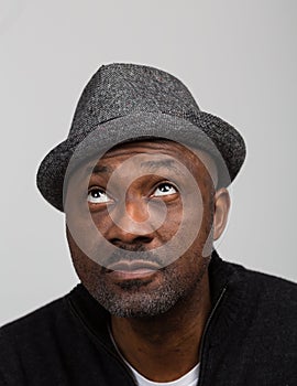 Black Man With Stubble Wearing A Hat looking Up