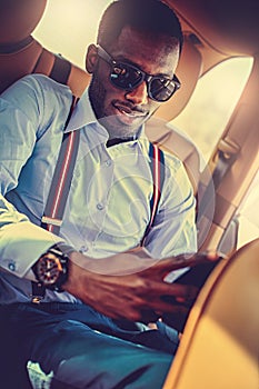 A black man in sunglasses sitting in the car.