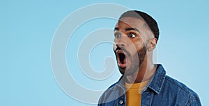 Black man, surprise announcement and shock on face, expression and drama on blue background. Wow, reaction to news and