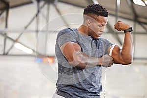 Black man, tape measure and bicep with muscle and strong athlete, weightlifting and fitness in gym. Power, challenge and