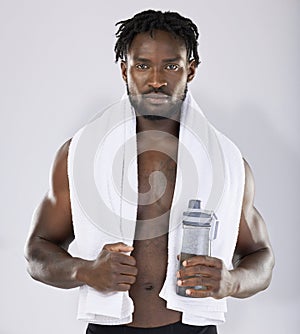 Black man, towel and water for fitness portrait of sports person in studio for strong body. Health and wellness of sexy