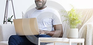 Black man typing text or programming code on laptop