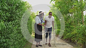 A black man was using a walker to learn to walk down the aisle, with his lover support nearby.