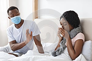 Black man wearing face mask while his wife is sick