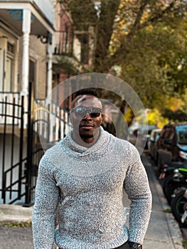 Black Man  wearing a winter sweater and sun glasses