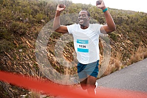 Black man, winner of race and fitness with cheers, athlete and sports with running in street and competition. Marathon