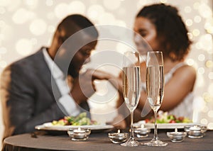 Black man and woman having romantic date at restaurant