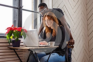 A black man and a woman warking with laptop.