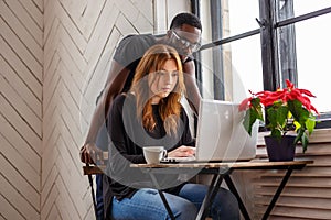 A black man and a woman warking with laptop.