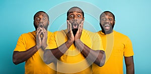 Black man with wondered, surprised and happy expression on cyan background