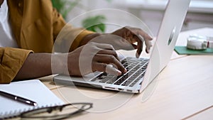 Black man working on white laptop at desk against background of office at home Spbas.