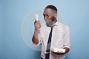 Black man yells into telephone receiver