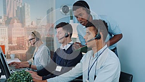 Black manager operator helping his colleague in call center