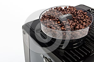 Black manual coffee maker on white background, grinder with fresh coffee beans detail top view