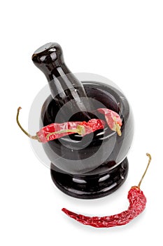 Black marble mortar and pestle with red chilli pepper isolated on white