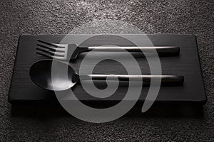 black matte fork with spoon close-up. on a dark background
