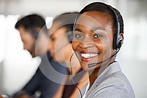 Black mature customer service woman on call with big smile