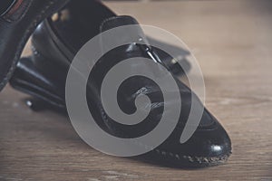 Black mens shoes on a wooden table