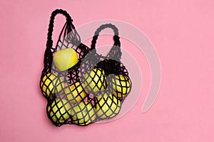 Black mesh shopping bag with organic green apples