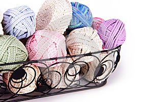 Black metal basket filled with Romanian Point Lace Macrame crochet cords in various colors to be used make tablecloth and doily cr